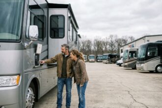 Couple de voyageurs examinant un camping-car moderne chez un concessionnaire spécialisé en plein air