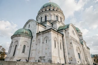 Vue en contre-plongée de la façade extérieure du temple Saint-Sava à Belgrade avec son imposant dôme blanc et ses coupoles en cuivre vert