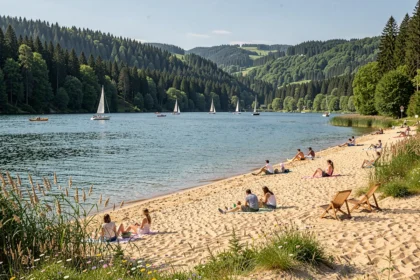Vue panoramique d'une plage au bord d'un lac dans le Grand Est avec forêts et familles profitant du soleil