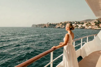 Femme sur le pont d'un bateau de croisière admirant la côte méditerranéenne lors d'une mini croisière de trois jours